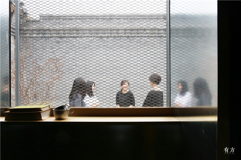由黑色展廊中的个人阅读空间看向庭院 摄影王艺祺